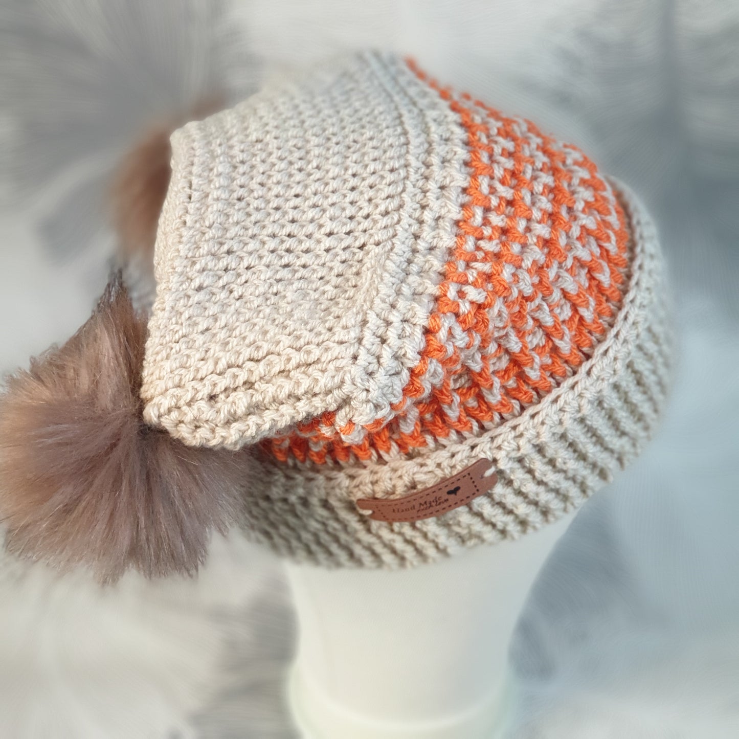 Crocheted corner hat with two faux fur pompoms