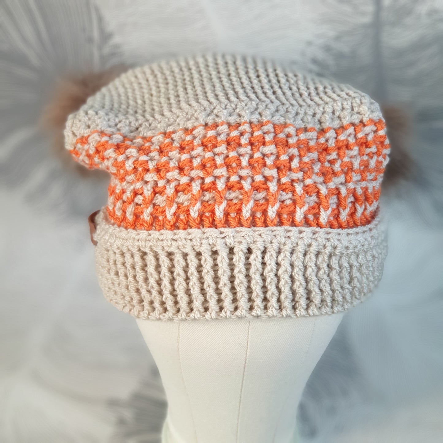 Crocheted corner hat with two faux fur pompoms