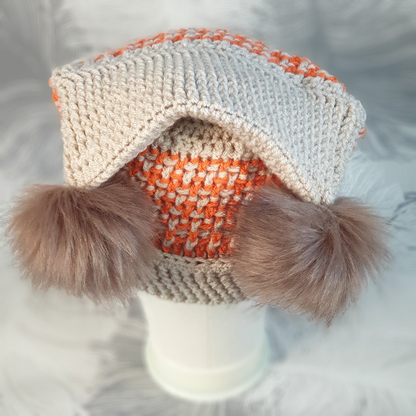 Crocheted corner hat with two faux fur pompoms