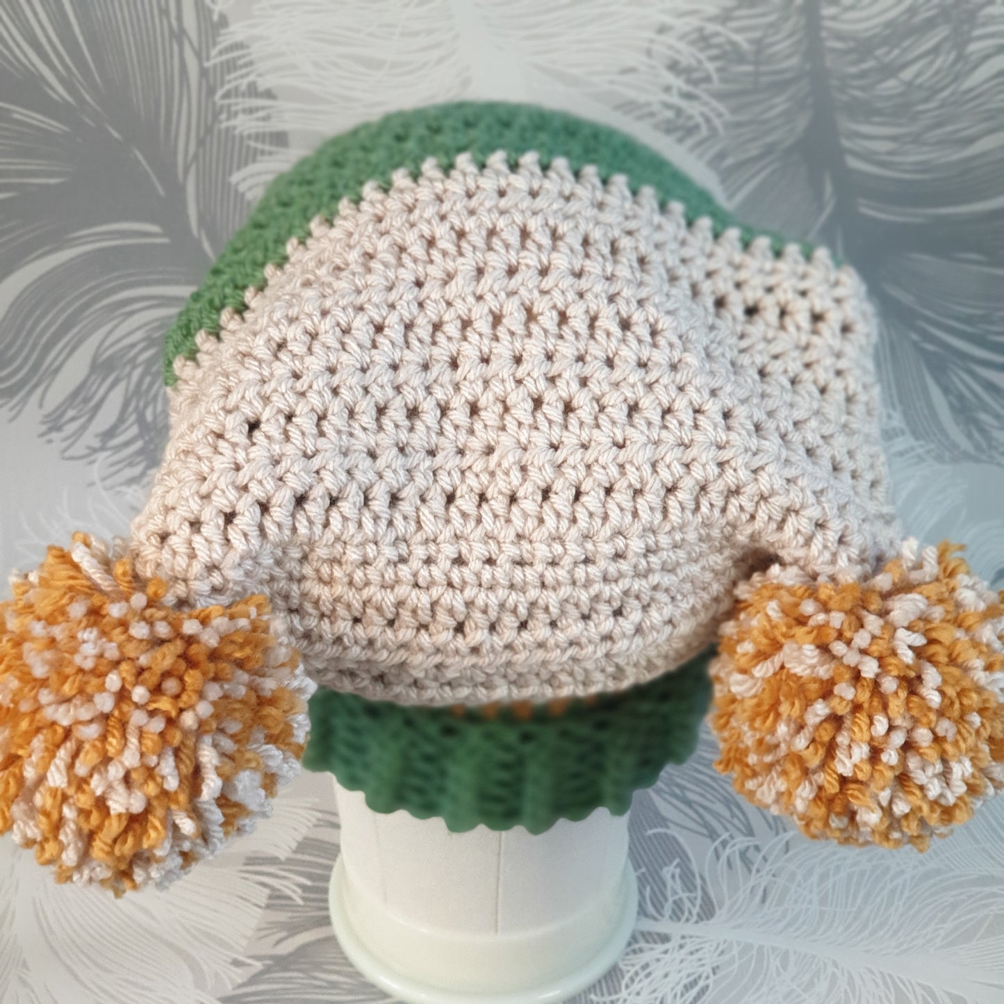 Crocheted double pompom corner hat